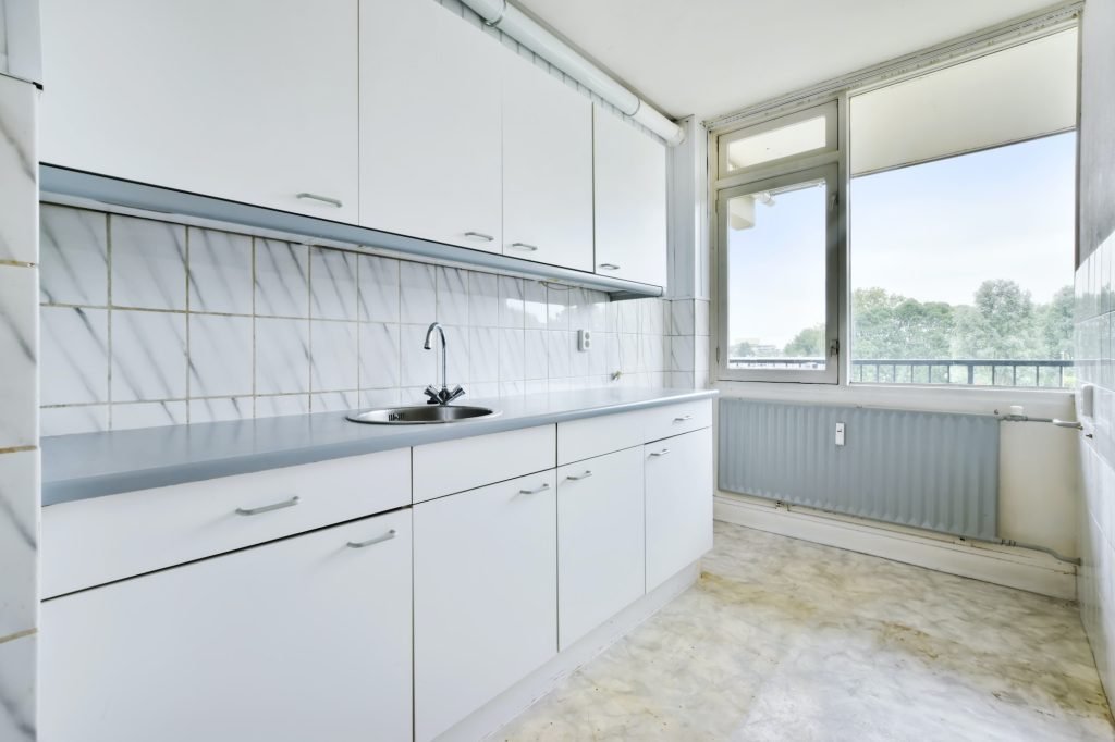 An empty and bright kitchen with a white kitchen set eves cleaning utah