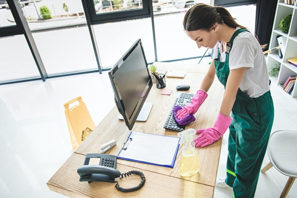 high angle view of young woman in rubber gloves cleaning office table-commercial-business cleaning-eves utah